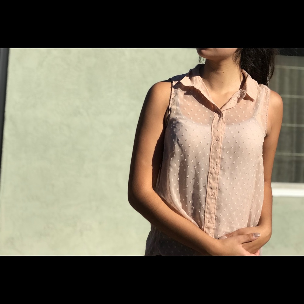 Cream, sleeveless, collared blouse.